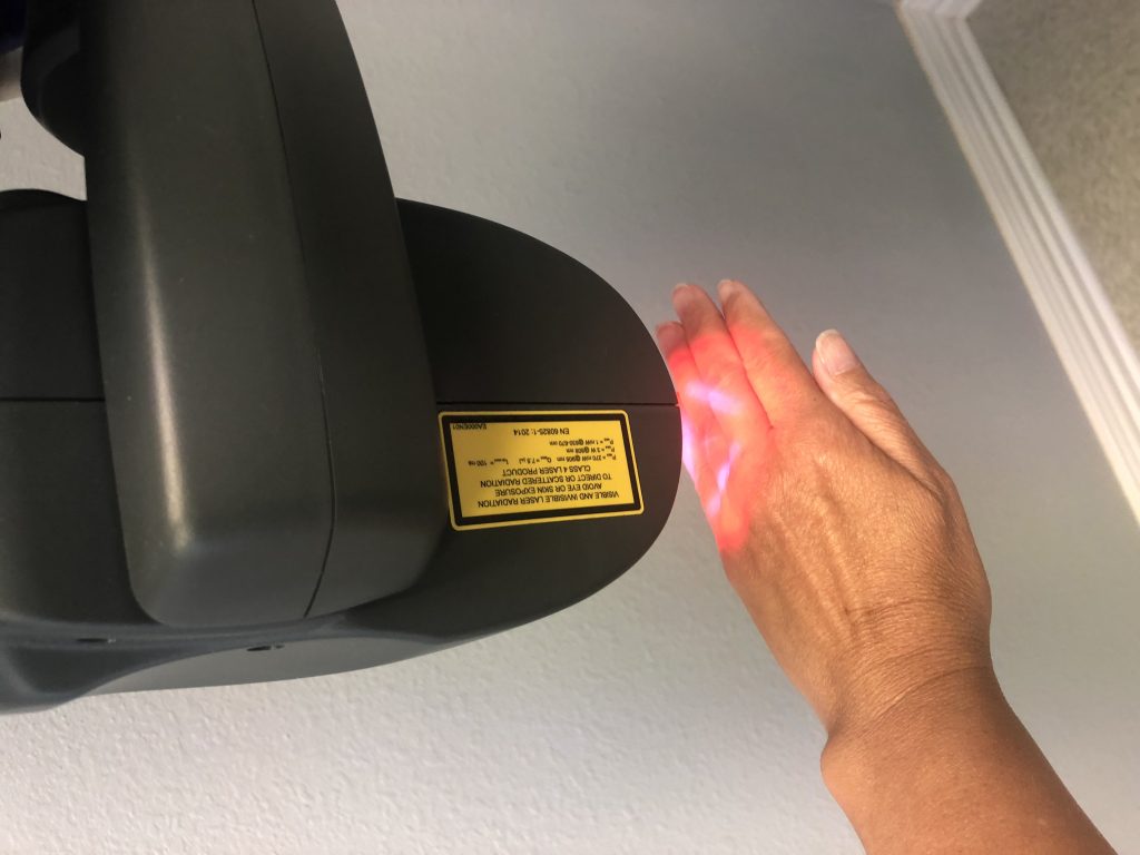 MLS Laser Therapy being applied to a patient hand